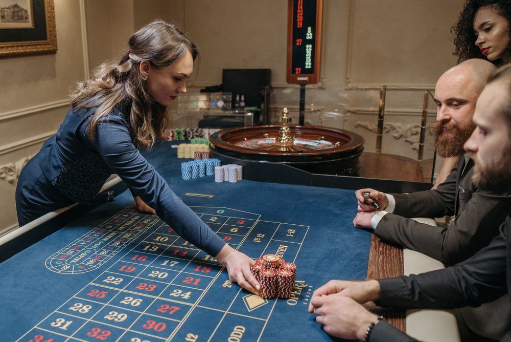 Meja roulette dengan dealer dan chip
